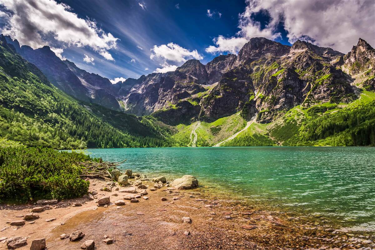 Фотошпалери літній день біля озера в оточенні зелених гір